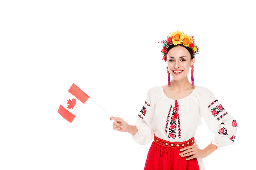 брюнетка молода жінка в національному українському костюмі Холдинг прапор Канади ізольований на білому - Фото, зображення