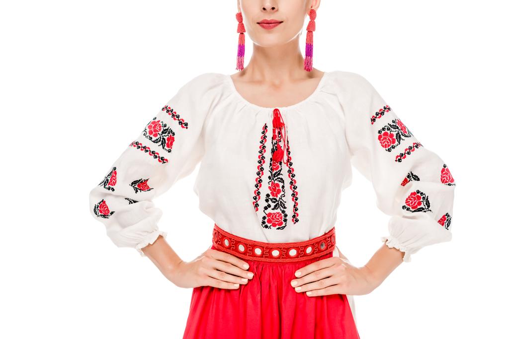 cropped view of young woman in national Ukrainian costume standing with hands on hips isolated on white - Photo, Image