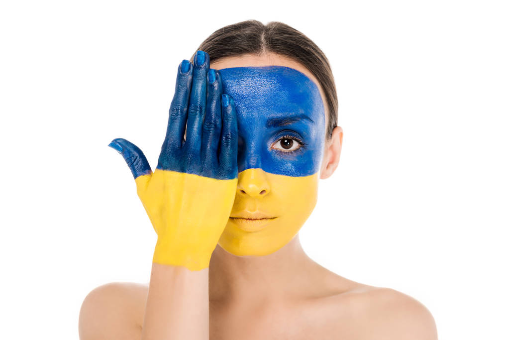 serieuze naakte jonge vrouw met geschilderde Oekraïense vlag op de huid geïsoleerd op wit - Foto, afbeelding
