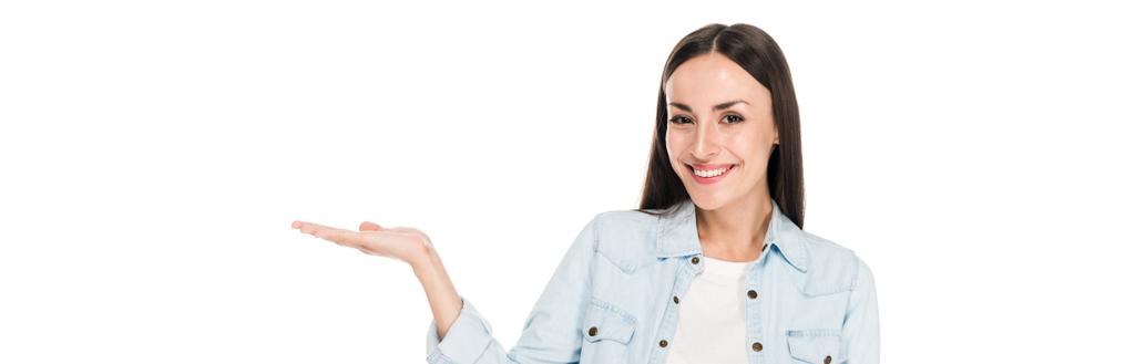 glückliche brünette Frau zeigt mit isolierter Hand auf weiße, panoramische Aufnahme - Foto, Bild