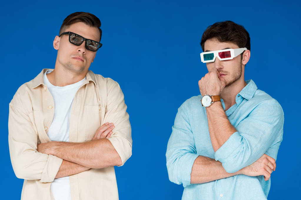 dos amigos serios en gafas 3D aisladas en azul
 - Foto, Imagen
