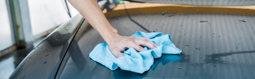 tiro panorâmico do homem limpando carro molhado com pano azul
  - Foto, Imagem