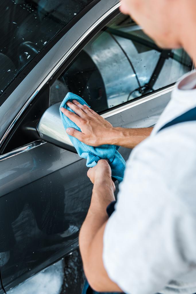 przycięte widok myjki samochodowej czyszczenia mokrego samochodu lustro z niebieskim RAG  - Zdjęcie, obraz