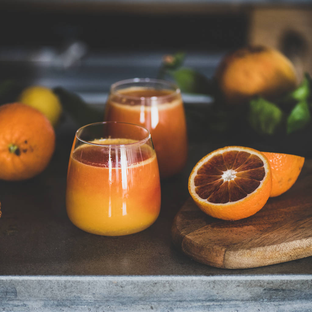 Glasses of freshly squeezed blood orange juice or smoothie on concrete kitchen counter, square crop, close-up. Healthy lifestyle, vegan, vegetarian, alkaline diet, spring detox concept - Photo, Image