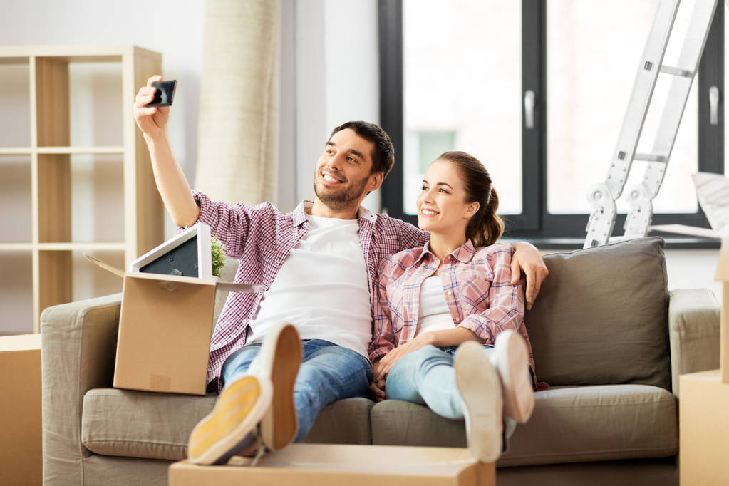 Paar macht Selfie mit Smartphone im neuen Zuhause - Foto, Bild