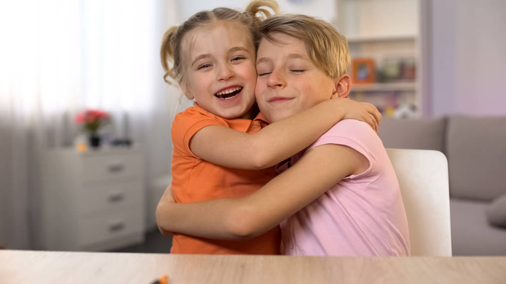 Счастливый мальчик и девочка обнимаются, брат сестра близость, нежные семейные отношения
 - Фото, изображение