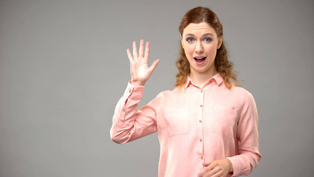 Donna sorda che dice ciao, come insegnante gesticolando parole in lingua dei segni, tutorial
 - Foto, immagini