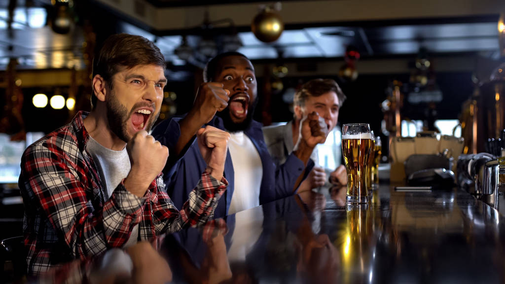 Joyful amigos multirraciais torcendo por equipe favorita no bar, celebrando objetivo
 - Foto, Imagem