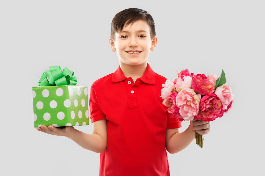 garçon souriant avec boîte cadeau d'anniversaire et fleurs
 - Photo, image