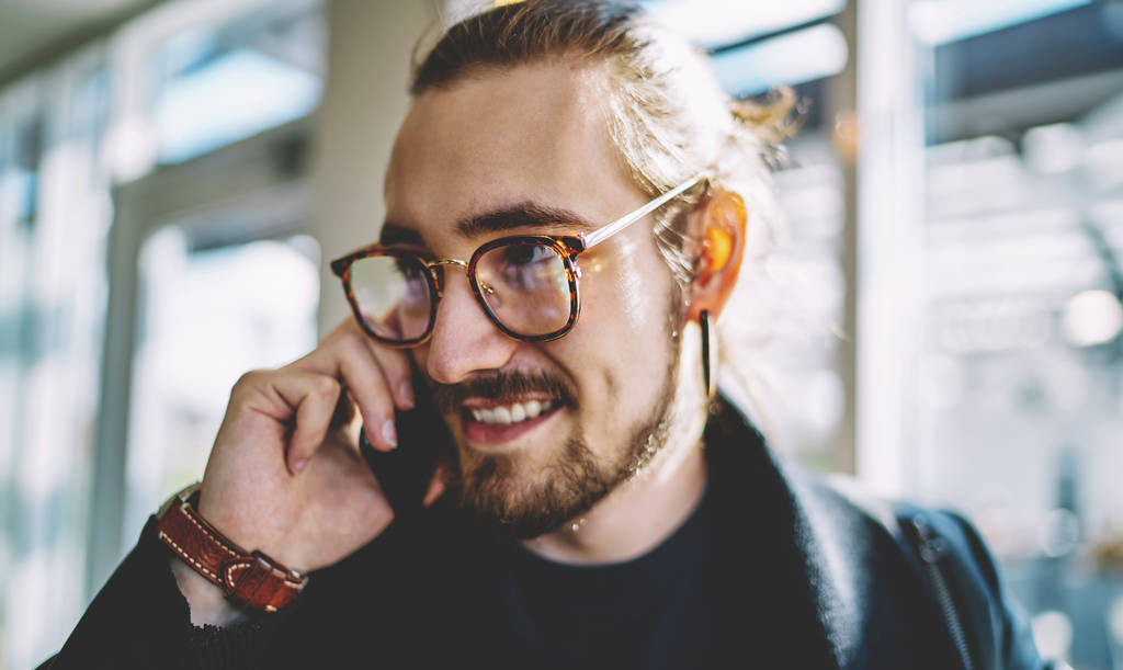 Běloch vousatý hipster chlap se usmívá během pozitivní smartphone konverzace s nejlepším přítelem, šťastný muž student komunikovat s kolegy z univerzity těší 4g bezdrátové připojení - Fotografie, Obrázek