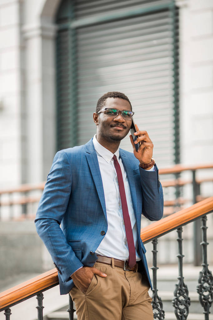 knappe jonge Afrikaanse man in een pak praten op de telefoon - Foto, afbeelding