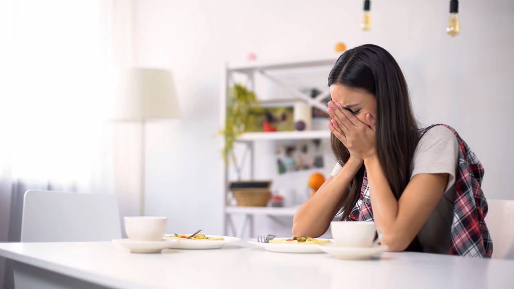 Jovem triste mulher sentada sozinha na cozinha e chorando após a briga, depressão
 - Foto, Imagem