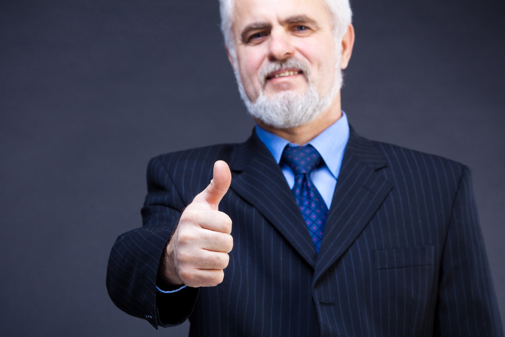 Студийный снимок бизнесмена, показывающего большой палец вверх вывеской на черном фоне
 - Фото, изображение