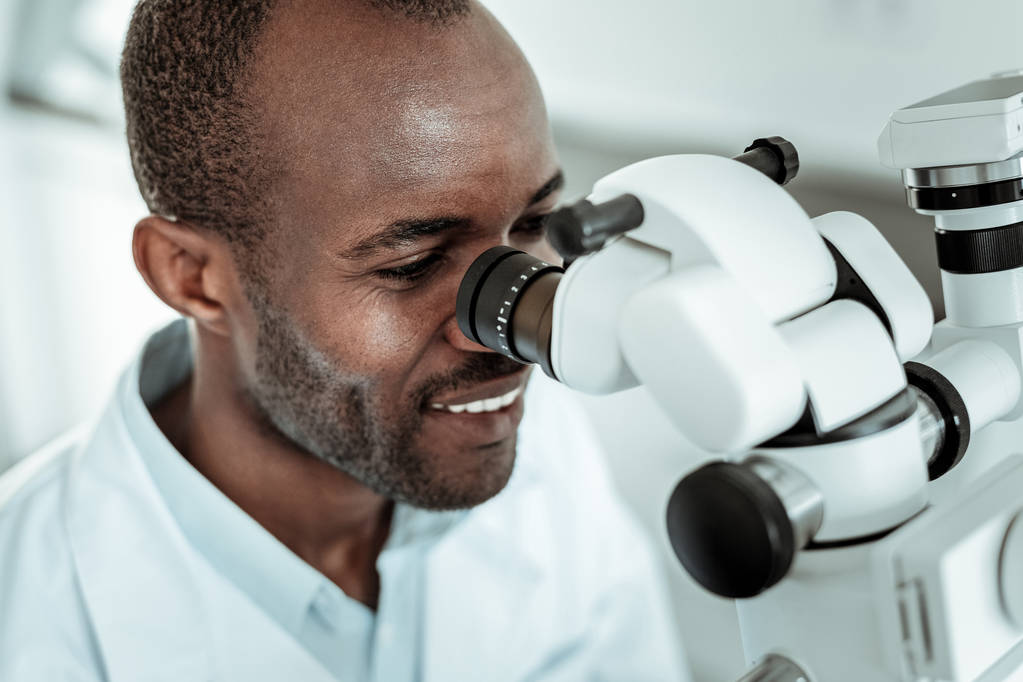 Επαγγελματίας θετικός γιατρός αναθεώρηση ασθενής με ειδικό μικροσκόπιο - Φωτογραφία, εικόνα