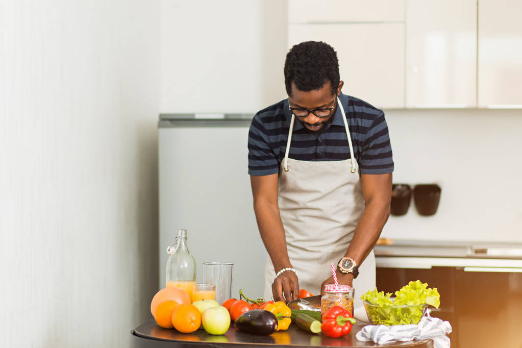 Afričan připravuje zdravé jídlo doma v kuchyni - Fotografie, Obrázek