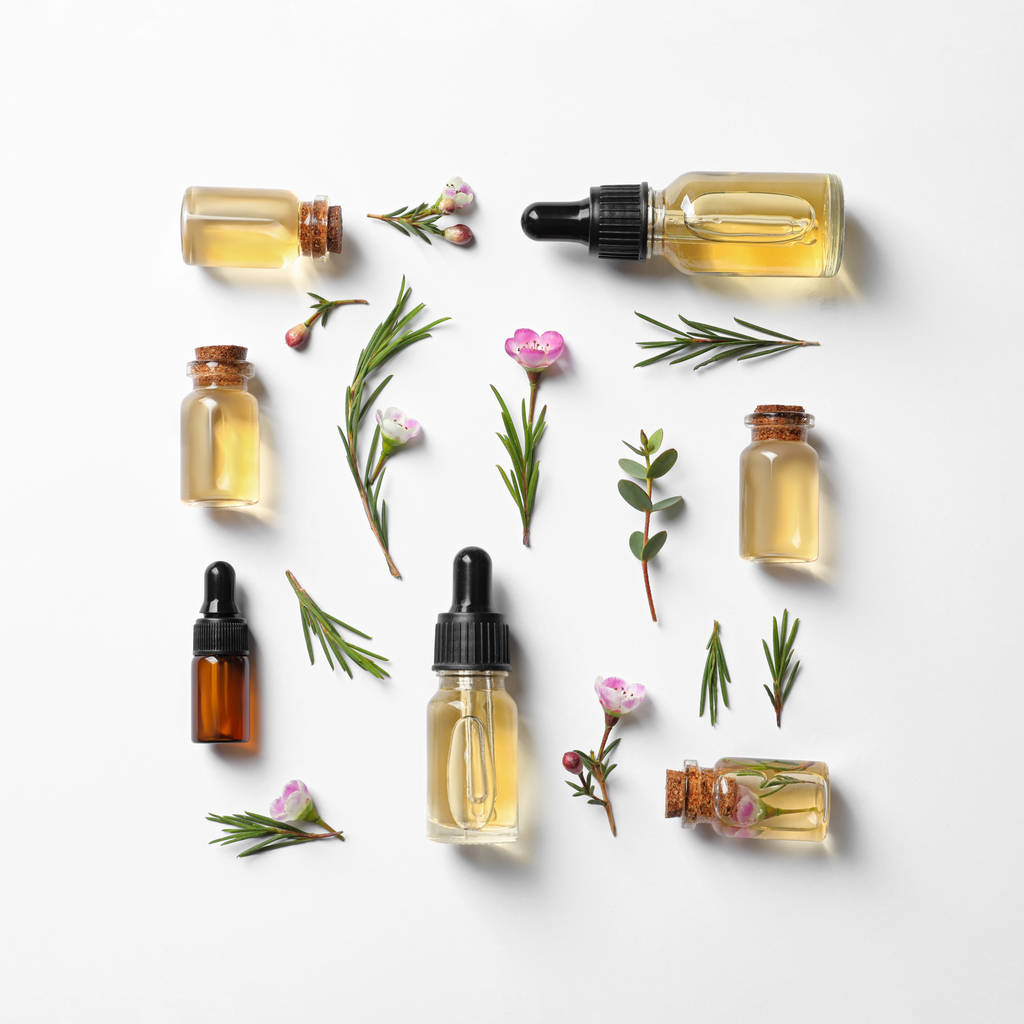 Płaska kompozycja z butelkami naturalnego olejku z drzewa herbacianego na białym tle - Zdjęcie, obraz