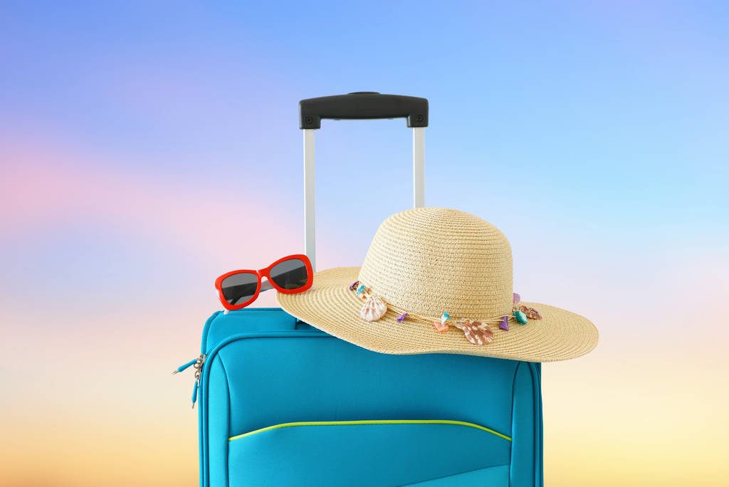 休日。旅行の概念。ボケの背景の前に青いスーツケース - 写真・画像