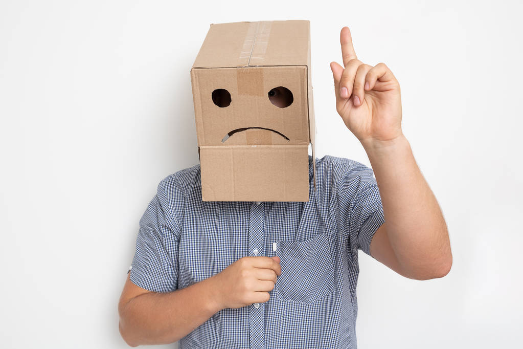 чоловік з картонною коробкою на голові, сумний усміхнений
 - Фото, зображення