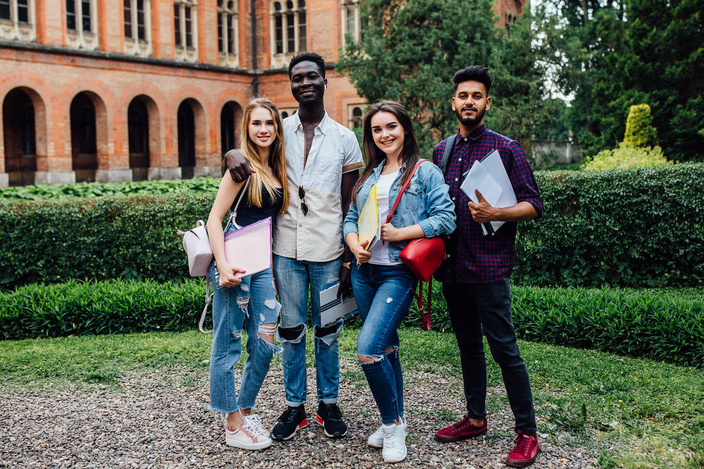 Üniversite yakınında birlikte yürüyen ve sarılan çok ırklı öğrenci grubu. - Fotoğraf, Görsel