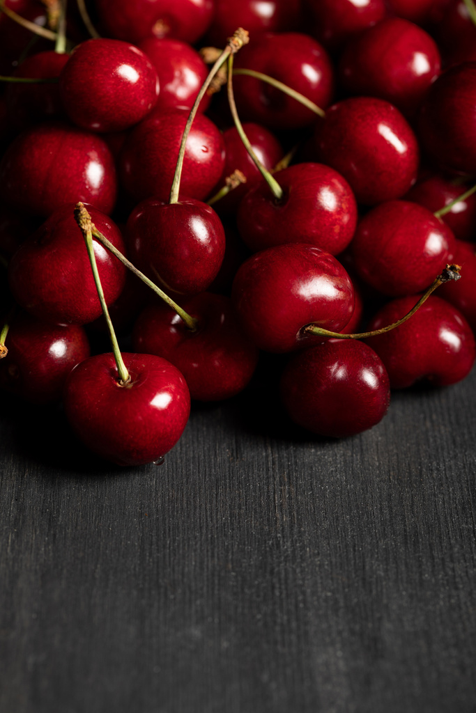 punainen herkullisia kirsikoita hajallaan puinen tumma pöytä
 - Valokuva, kuva
