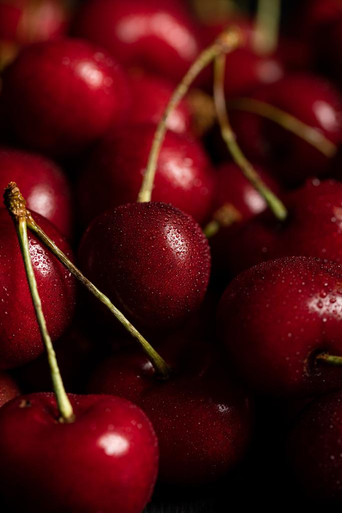 Blízká pohled na červené chutě a zralé třešně s kapkami vody - Fotografie, Obrázek