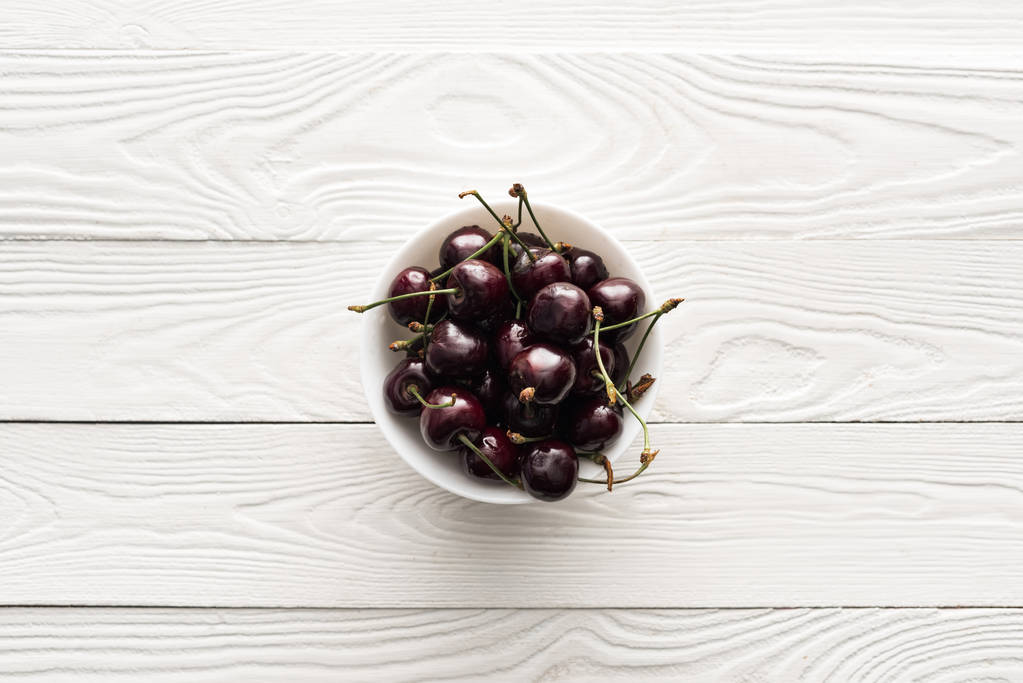 vista superior de cerezas frescas, dulces y maduras en un tazón sobre fondo de madera
  - Foto, Imagen