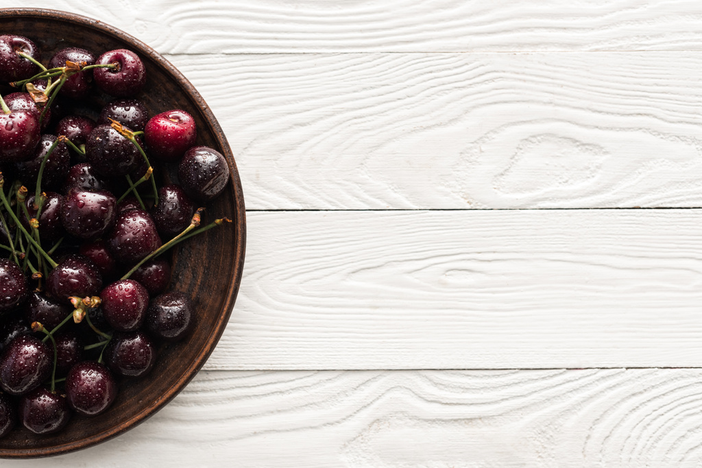 вид сверху на свежие, сладкие и спелые вишни, покрытые каплями на тарелке
  - Фото, изображение