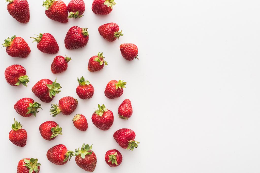 vista dall'alto di fragole dolci e rosse su sfondo bianco con spazio copia
  - Foto, immagini