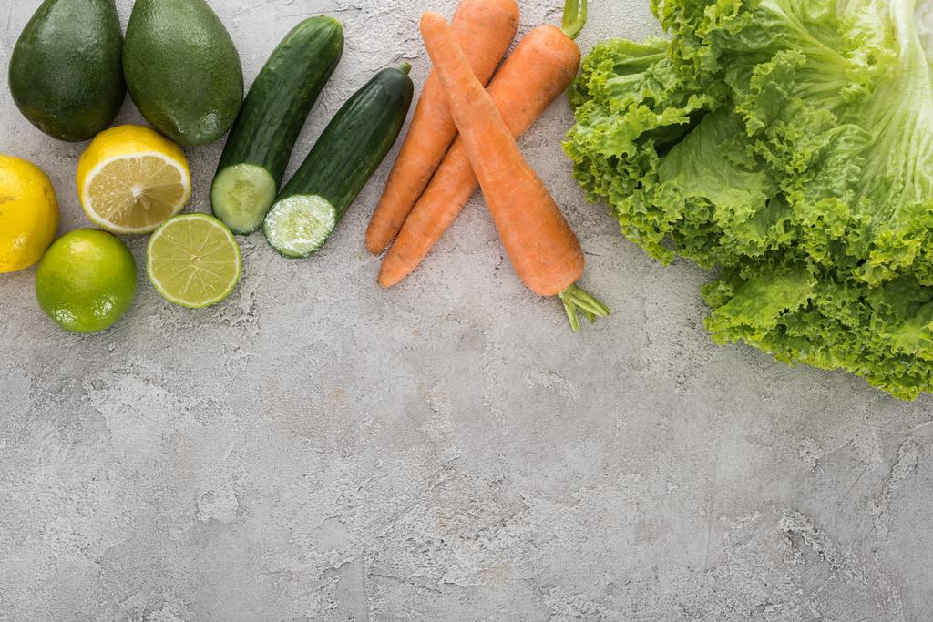 вид сверху на лимоны, лаймы, авокадо, морковь и салат на столе
  - Фото, изображение
