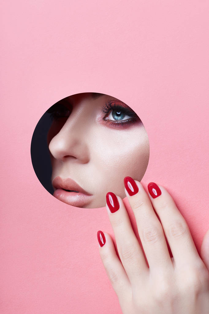 Краса обличчя червоний макіяж пухкі губи червоні цвяхи молодої дівчини в
 - Фото, зображення
