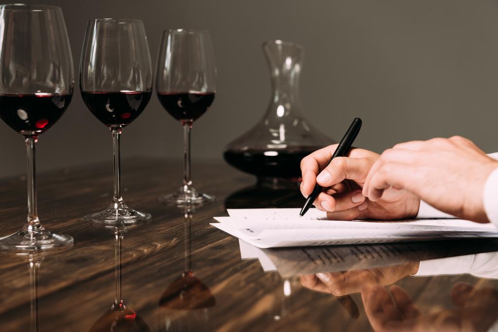 vista parziale della scrittura sommelier a tavola con bicchieri di vino
 - Foto, immagini