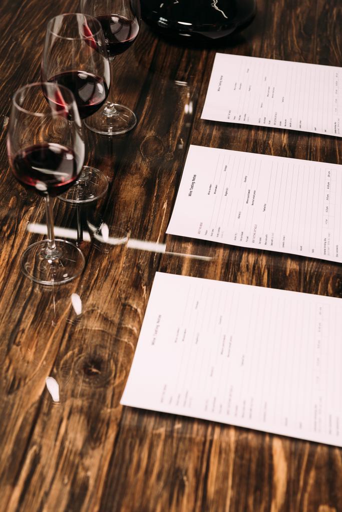 木製テーブルのワインテイスティングドキュメントとワイングラス - 写真・画像
