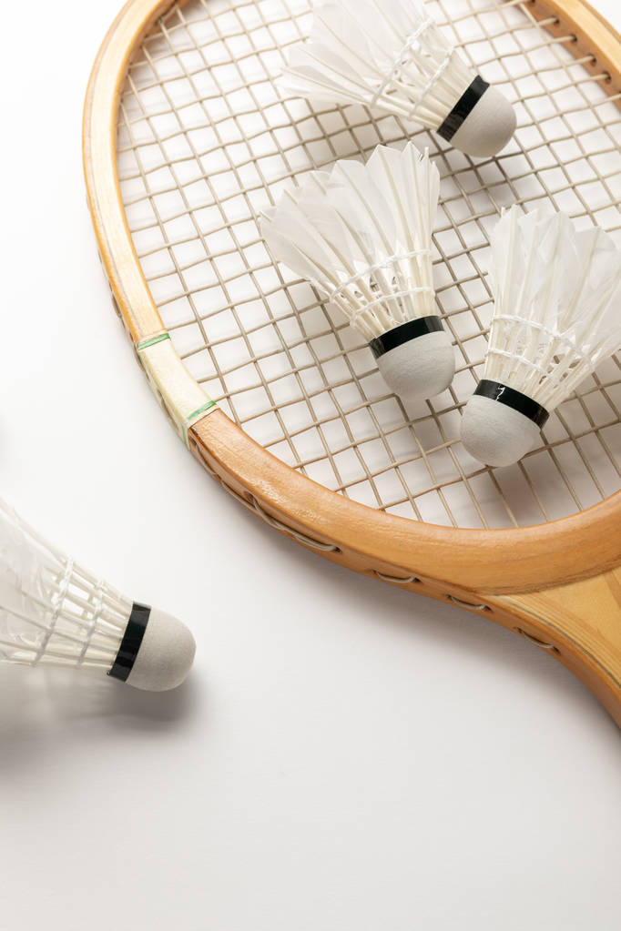 close up view of wooden badminton racket and shuttlecocks on white background - Photo, Image