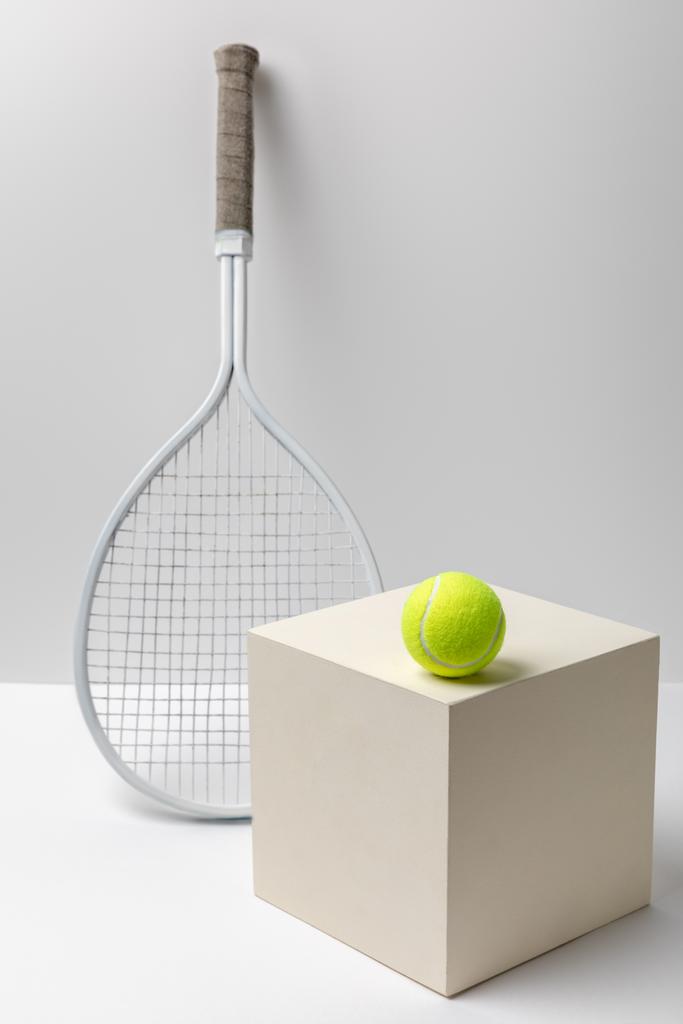 raquette de tennis et balle de tennis jaune vif sur cube sur fond blanc
 - Photo, image
