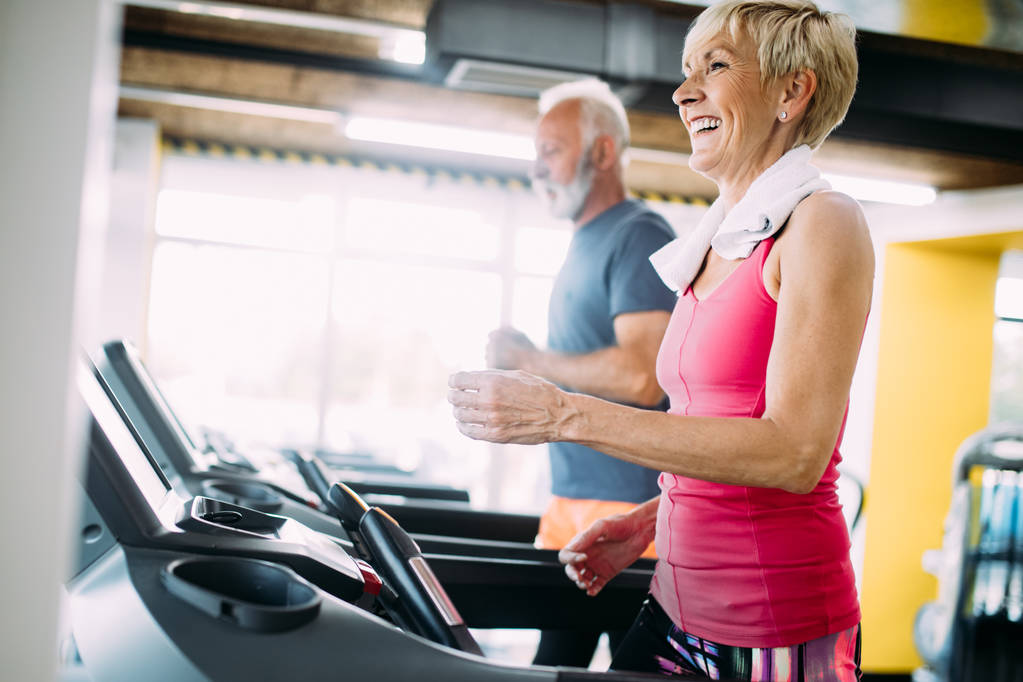 Picture of mature people running on treadmill in gym - Photo, Image