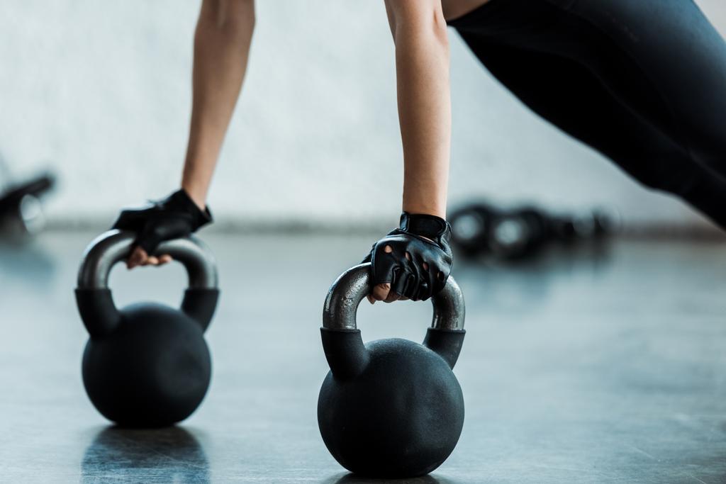vista recortada de una joven haciendo ejercicio con pesas
  - Foto, Imagen