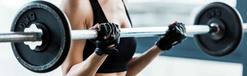 Panoramaaufnahme einer Frau beim Training mit der Langhantel im Fitnessstudio  - Foto, Bild