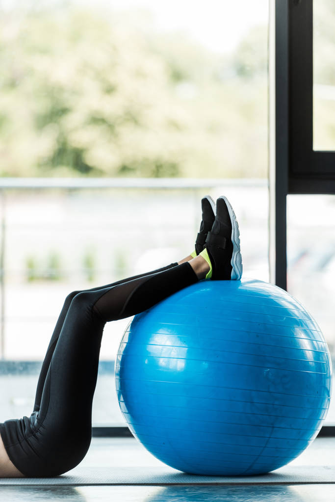 vista recortada de la mujer haciendo ejercicio con la pelota de fitness en la estera de fitness
  - Foto, imagen