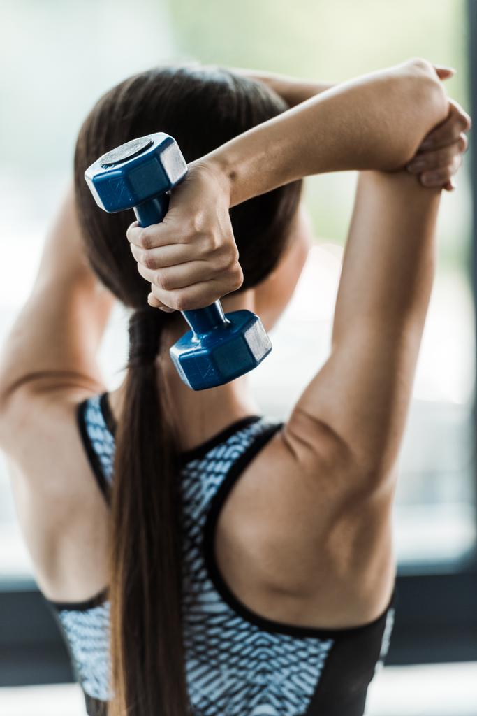 back view of sportswoman working out with dumbbell  - Photo, Image
