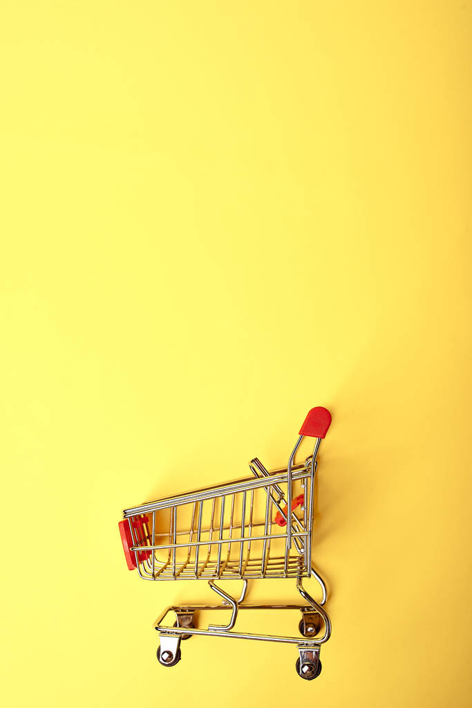 Einkaufswagen auf gelbem Hintergrund - Foto, Bild