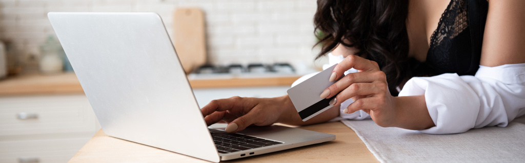panoráma lövés lány fekete fehérnemű és fehér inget használ laptop és a Holding hitelkártya - Fotó, kép