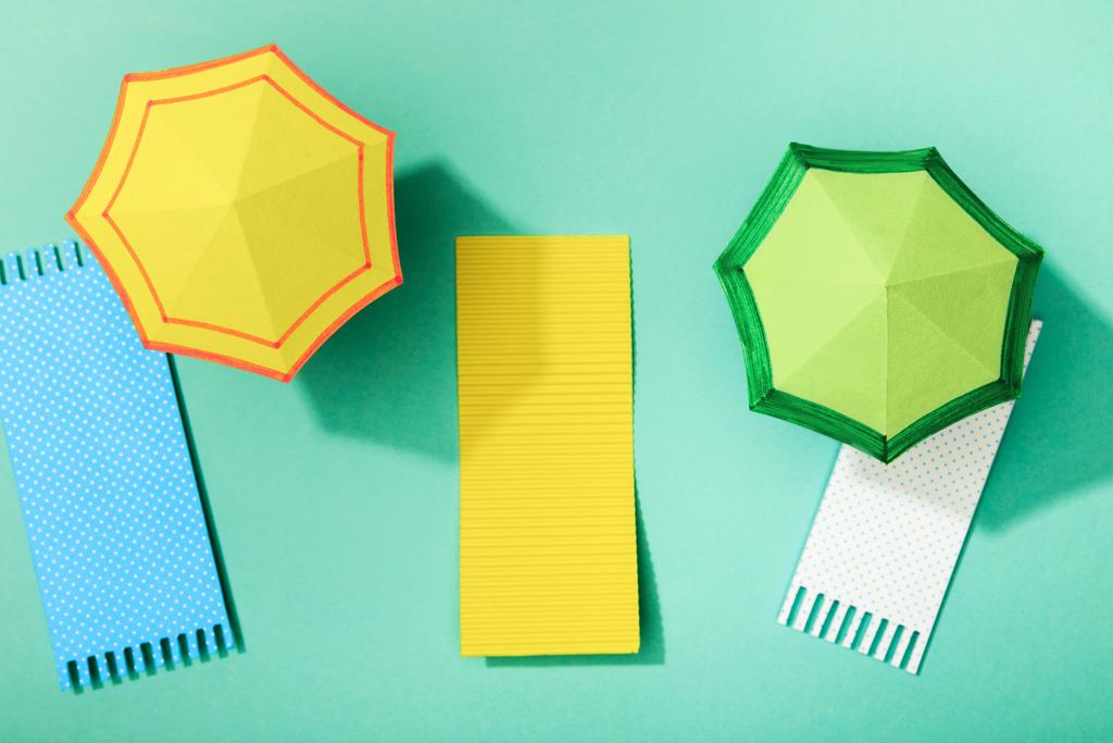 top view of paper towels and umbrellas on turquoise background - Photo, Image