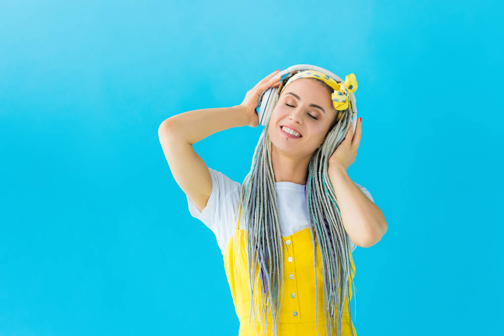 κορίτσι με ράμες στα ακουστικά χαμογελαστά απομονωμένα σε τυρκουάζ - Φωτογραφία, εικόνα