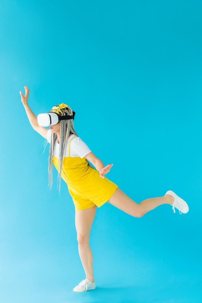 девушка с дредами в гарнитуре виртуальной реальности жестом на бирюзовый
 - Фото, изображение