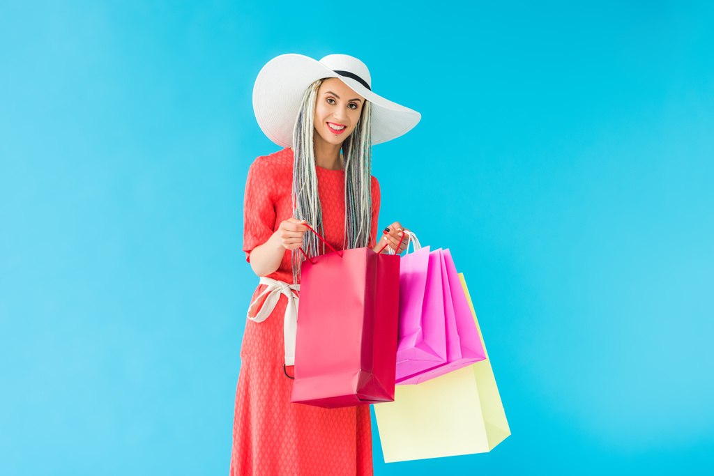 mooi stijlvol meisje met boodschappentassen geïsoleerd op Turquoise - Foto, afbeelding