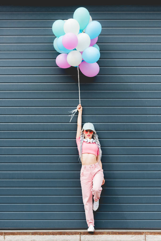 stylisches Mädchen posiert mit dekorativen Luftballons in Wandnähe - Foto, Bild