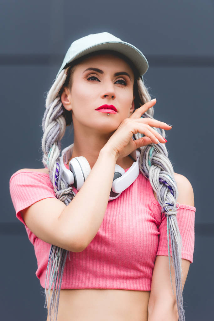όμορφο κομψό κορίτσι με ντρίνες και τα ακουστικά κοιτάζοντας μακριά - Φωτογραφία, εικόνα