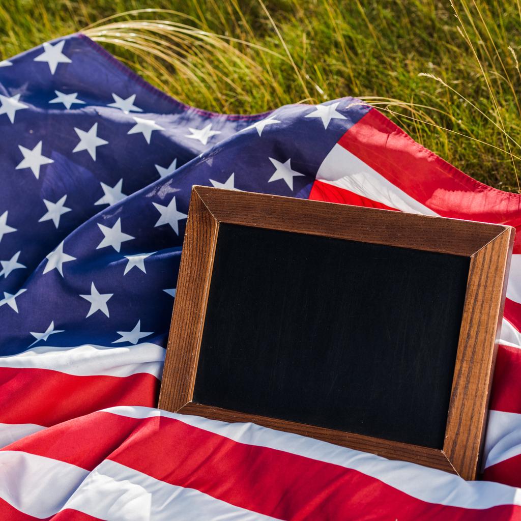 close up of empty chalkboard on american flag with stars and stripes  - Photo, Image