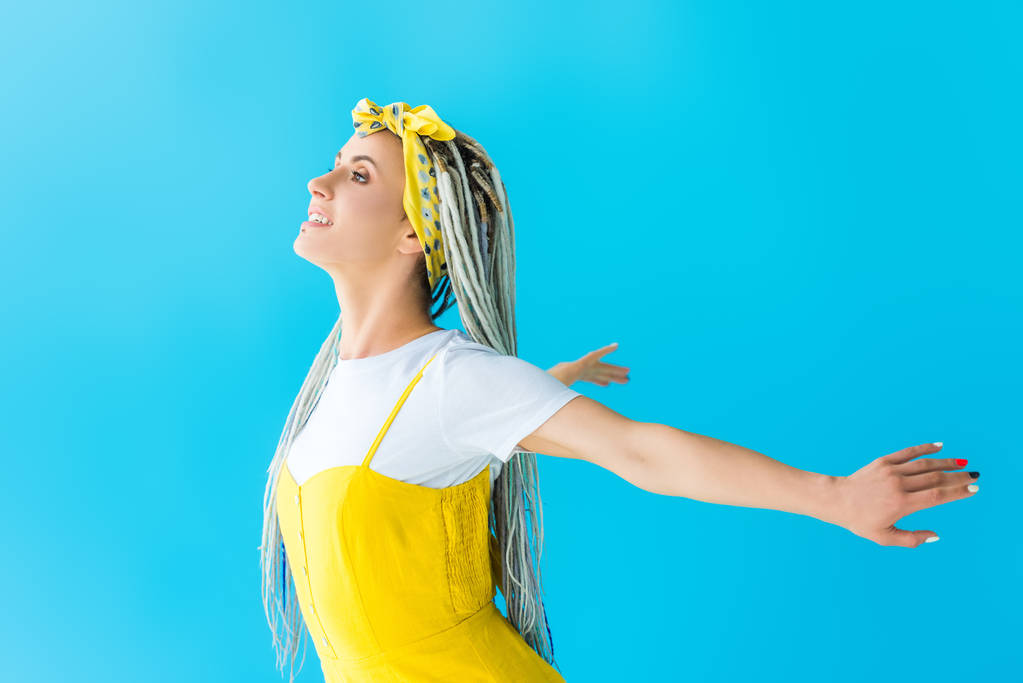 gelukkig meisje met dreadlocks met uitgerekt handen poseren geïsoleerd op Turquoise - Foto, afbeelding