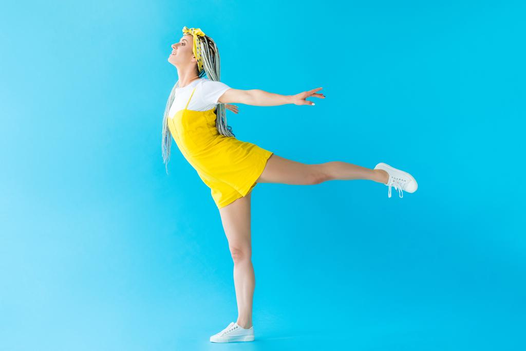 šťastná dívka s dredy s roztaženými pracky a nohou na tyrkysové - Fotografie, Obrázek